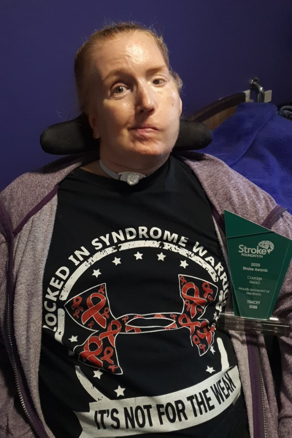 Image of Tracey with her award from the Stroke Foundation, wearing a tshirt for LiS Warriors